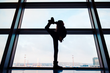 Fototapeta premium Little girl in airport near big window while wait for boarding