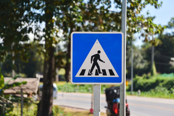 Road sign Crosswalk / traffic sign pedestrian crossing blue background in the roadside