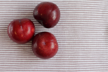 three natural fresh plums on table