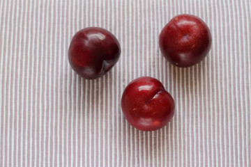 three natural fresh plums on table