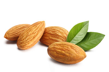 Obraz na płótnie Canvas Close-up of almonds with leaves, isolated on white background