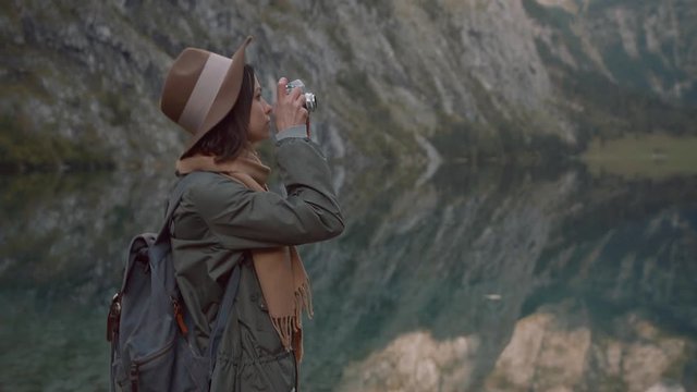 Young photographer with retro camera in the mountains