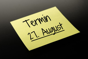 Termin 27. August - gelber Notizzettel dunkler Hintergrund