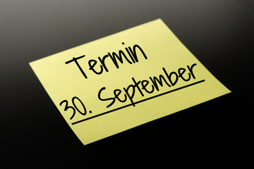 Termin 30. September - gelber Notizzettel dunkler Hintergrund