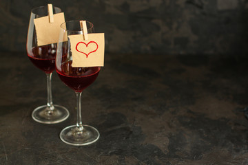 red wine, transparent glass (beverage and a note with a heart). top