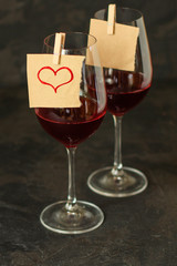 red wine, transparent glass (beverage and a note with a heart). top