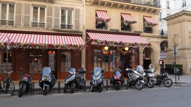 Paris France street moto scooters parked along sidewalk and building facade