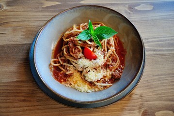 Spaghetti Bolognese, served with mint leaves and parmesan (Parmigiano-Reggiano) cheese