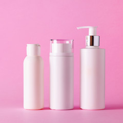 White cosmetic tubes on pink background with copy space. Skin care, body treatment, beauty concept. Square crop