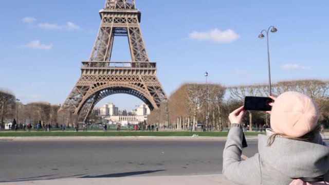 Paris France woman tourist takes smartphone picture of the Eiffel tower