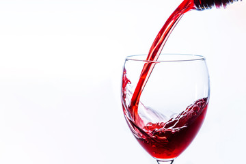 Close up of Red Wine Pouring Into Glass on light background, Alcohol abuse and alcoholism, celebration and party concept. With copy space.