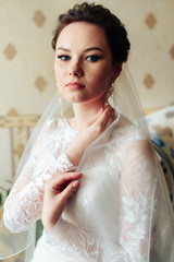 Fototapeta premium morning of the bride, a beautiful woman in a white dress is preparing for the wedding