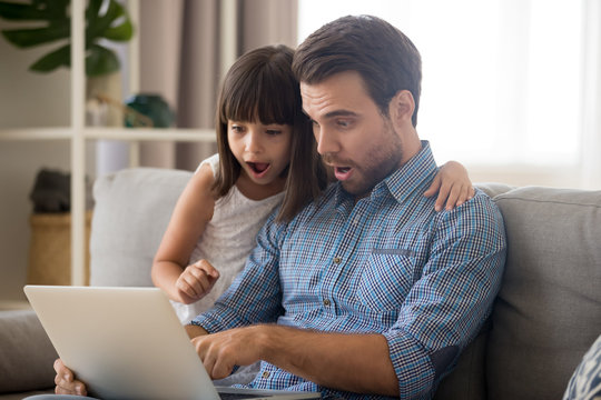 Surprised father and kid girl looking at computer screen using laptop, amazed dad and child daughter excited with unbelievable internet news, shocked by sale offers doing online shopping at home