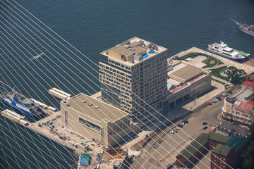 The central part of Vladivostok, taken from a height. In the frame of the Golden Bridge, the Golden Horn Bay, warships, the Sports Embankment, the Tsarevich Embankm © alexhitrov