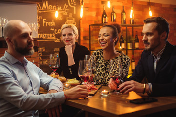 Group of friends having fun talk behind bar counter in a cafe