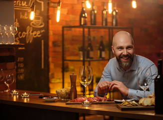 Middle-aged man sitting behind bar counter