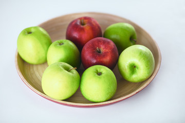 wooden plate with ripe fresh red and green apples