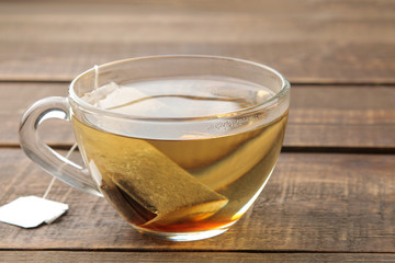 Tea bag in a glass cup on a brown wooden background. to make tea