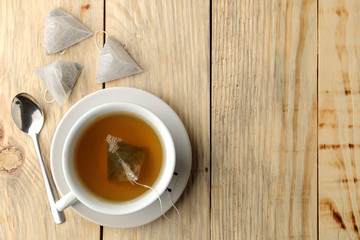 cup with tea and tea bag pyramid. close-up. on a wooden table. to make tea