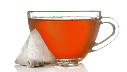 glass cup with tea and tea bag close up on white isolated background