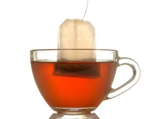 glass cup with tea and tea bag close up on white isolated background