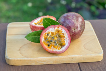 a passion fruit on the wooden table on the background of tropical garden