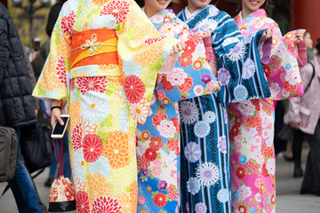Young girl wearing Japanese kimono standing in front of Sensoji Temple in Tokyo, Japan. Kimono is a...