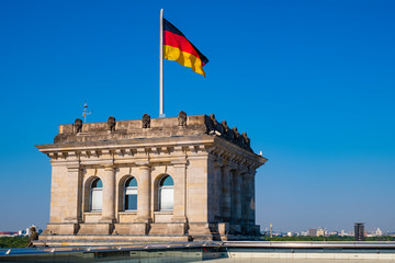 Berlin, Germany - Rooftop of the Reichstag building with the historic corner tower and Germany flag with Berlin skyline in background