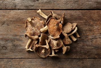 Delicious dried mushrooms on wooden background, top view