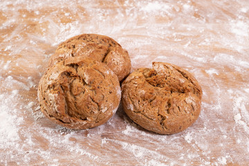Drei frisch gebackene Brötchen auf Backtisch