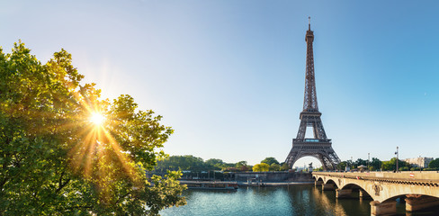 Fototapeta premium Paryska ulica z widokiem na sławną Paryż wieżę eifla w słonecznym dniu z niektóre światłem słonecznym
