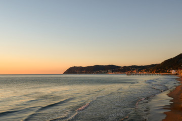 Scenic view at sunrise of the Ligurian coast from the beach of Alassio with Laigueglia and Capo Mele in the background, Liguria, Italy