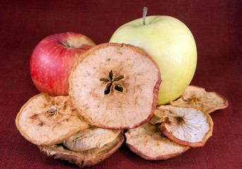 Pieces of dried apple and two fresh red and green apples
