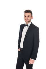 handsome elegant man posing in black tuxedo and tie bow isolated on white