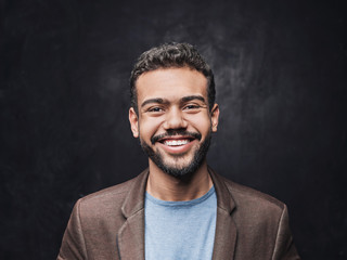 Portrait of handsome smiling young man. Laughing joyful cheerful men studio shot on black background