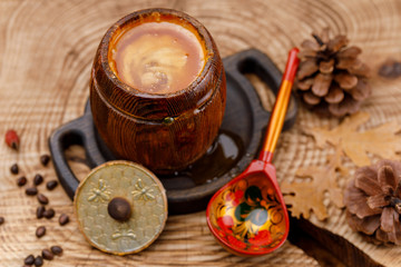 Barrel with honey and painted wooden Russian spoon.