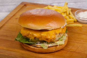 Homemade burger with fish, cheese and salad leaves