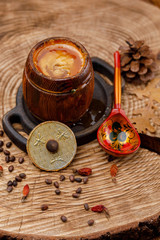 Barrel with honey and painted wooden Russian spoon on a wooden saw.