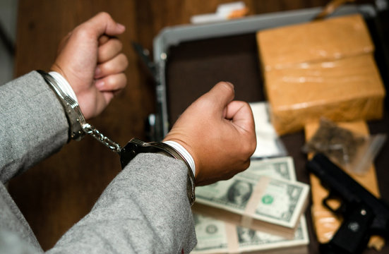 hands of a male drug dealer are handcuffed. The fight against drugs and crime.