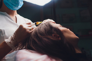 Beautiful woman getting injection for hair growth.