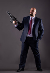 Man in a business suit with a gun