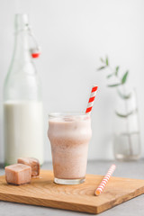 Cold fitness shake is made from milk, protein, cocoa and ice cubes. The concept of a healthy lifestyle and good mood.