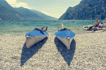 Pair of canoe lying on pebble beach.