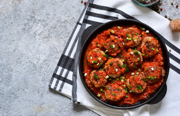 Meat balls in tomato sauce with spices concrete background. View from above.