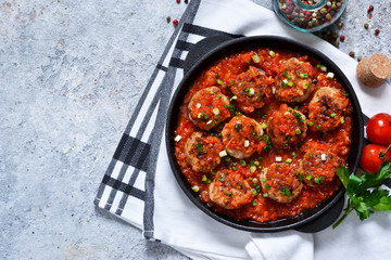 Meat balls in tomato sauce with spices concrete background. View from above.