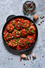 Meat balls in tomato sauce with spices concrete background. View from above.