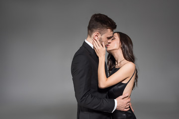beautiful elegant couple kissing and embracing isolated on grey