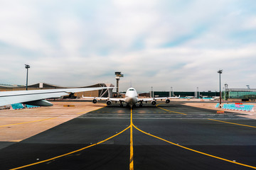 Airplane going to take of the ground and spectacular clouds on background.