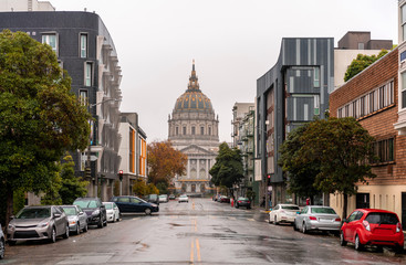 San Francisco city hall building with an empty street and morning fog over the city.