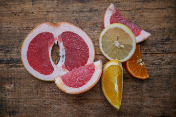 Fresh citrus fruits half cut on wooden background